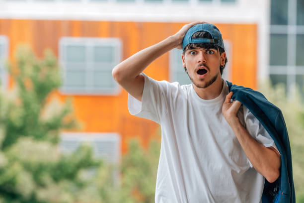 young man on the street with mobile phone and surprised expression