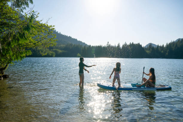 istock Mother and daughters enjoy SUP board on mountain lake 2192107060