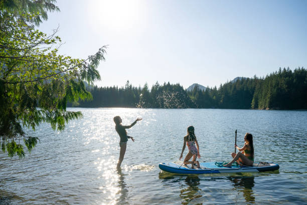 istock Mother and daughters enjoy SUP board on mountain lake 2192107062
