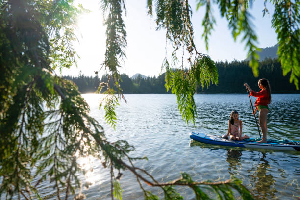 istock Mother and daughter enjoy SUP board on mountain lake 2192107169