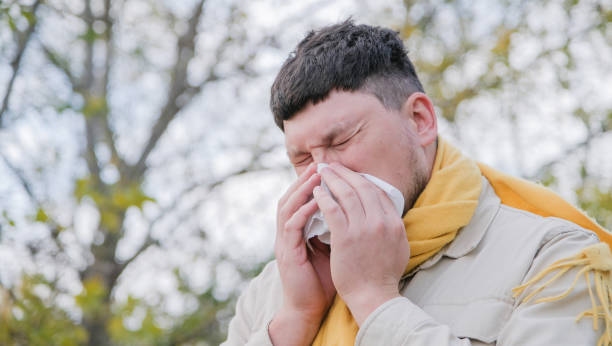 istock young man enjoying autumn days breathing fresh air using tissue to wipe nose 2192107404