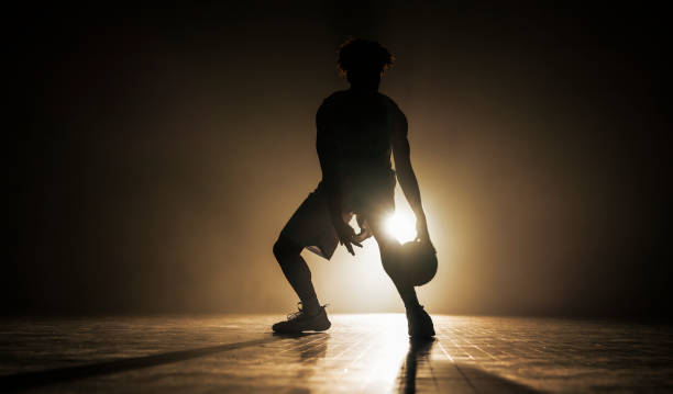 istock Male Basketball Player Silhouette Dribbling Ball 2192109331