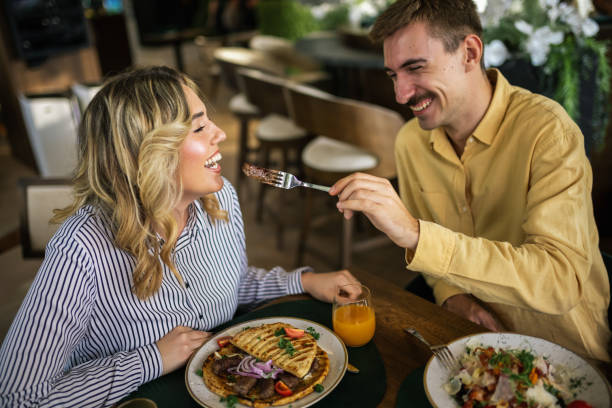 istock Cute couple feeding each other in a restaurant. 2192109770