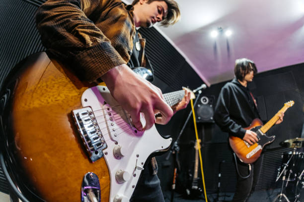 istock Guitarist Playing A Guitar During A Band Rehearsal In A Studio 2192112288