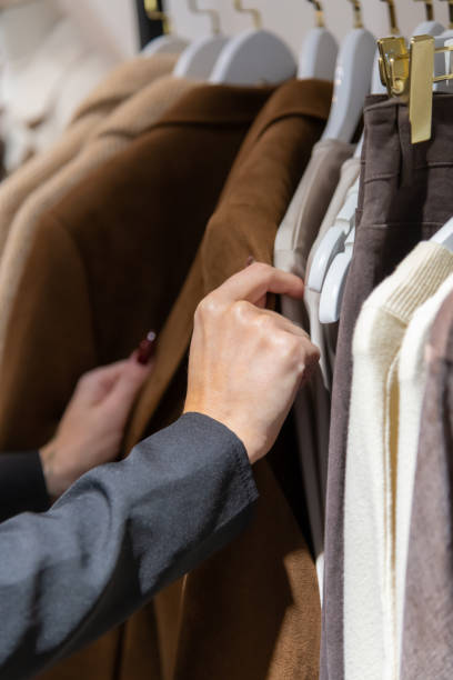 istock Female hands holding brown coat 2192116547