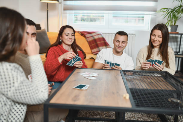 istock Happy Looking Friends Looking at Their Cards Planning Next Move in Card Game 2192121789