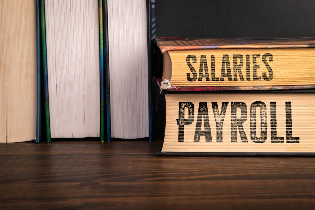 istock Payroll and Salaries Concept. Stack of books on a wooden shelf 2192122444
