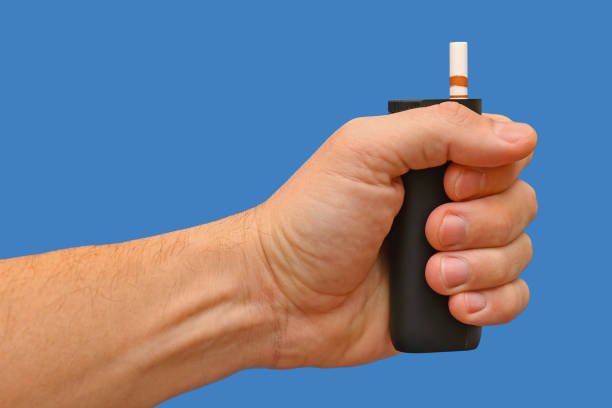 istock A device for electrically heating tobacco with a stick is held in the hand against a blue background. 2192122977