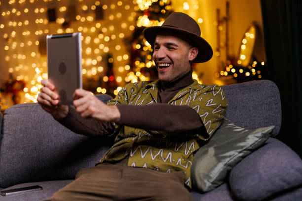 istock Man in festive atmosphere video chatting on tablet during Christmas celebrations 2192125175