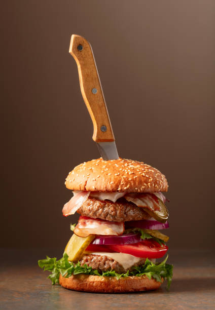 istock Fresh burger with knife on a brown background. 2192125791