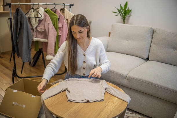 istock Young woman folding clothes before packing it for delivery to the customers. 2192129503