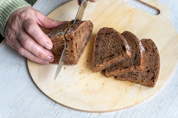 istock Fresh bread slice and cutting knife on table in kitchen. top view rye bread, 2192129756