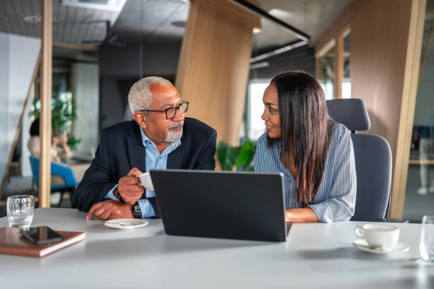 istock Senior Executives Collaborating on Laptop in Modern Office 2192130110