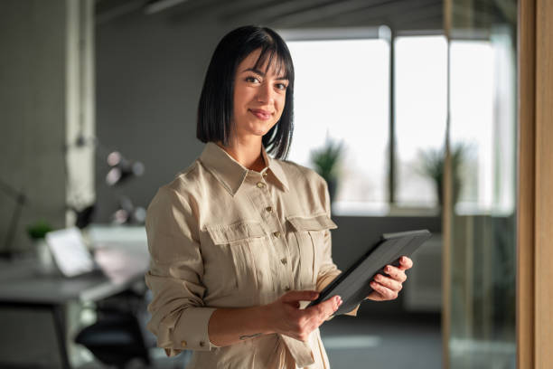 istock Confident Businesswoman Holding Tablet in Modern Office Setting 2192130132