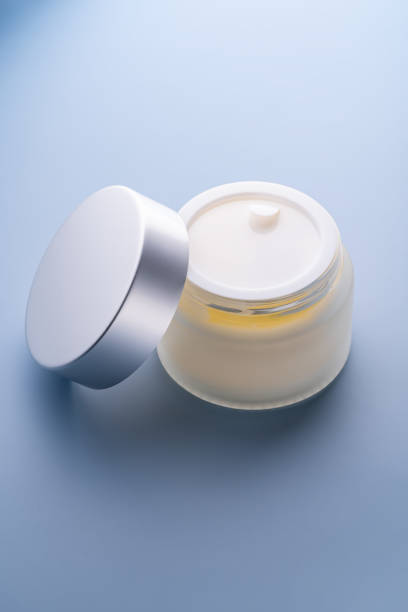 istock Nourishing face cream. Moisturizing natural cream with silver cap on blue background. Commercial presentation 2192131705