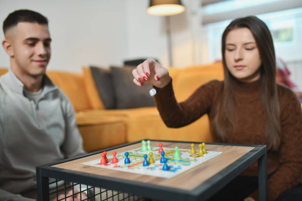 istock Focused Female Player Throwing Board Game Dice Hoping For Good Result 2192134019