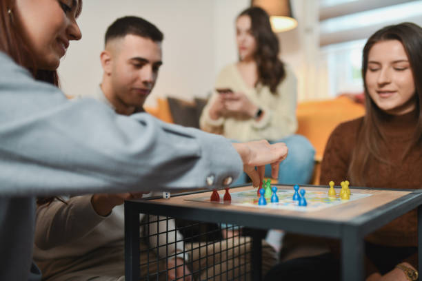 istock Focused Female Carefully Placing Figure on Board Game While Friends are Watching Her Every Move 2192134036