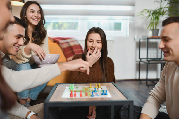 istock Friends Enjoying Fun Gathering Playing Board Games Snacking and Laughing Together 2192134045