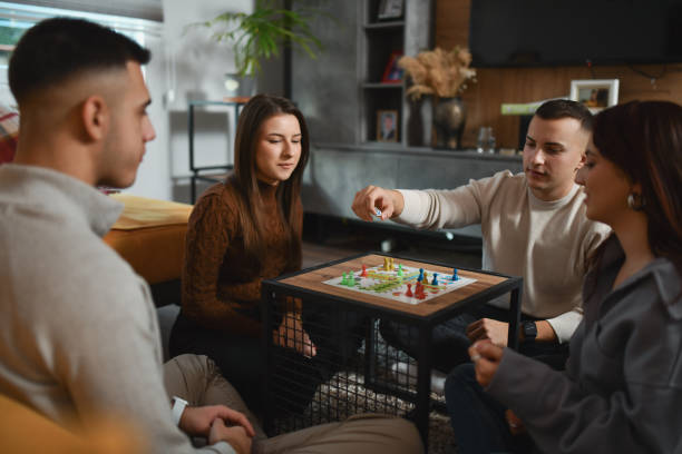 istock Male Friend Looking Focused Before Throwing Dice in Final Round of Board Game 2192134102