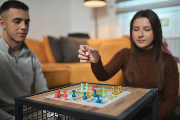istock Female Player Throwing Dice Hoping For Good Result in Board Game 2192134214