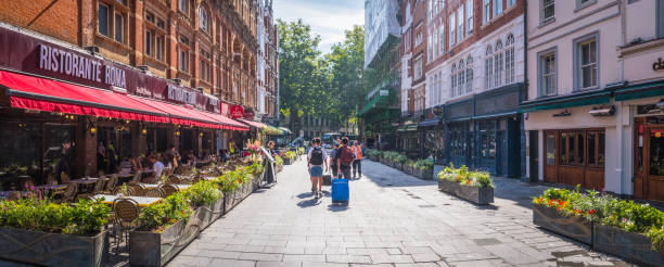 People walking past bars and restaurants to Leicester Square in the heart of London.