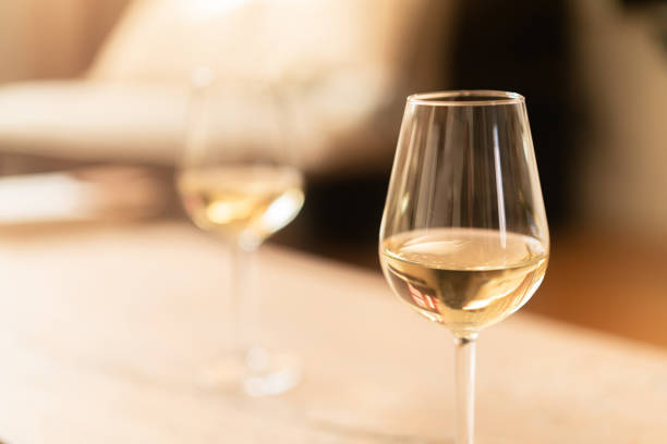 istock Two glasses of white wine on a rustic wooden table at home 2192138063