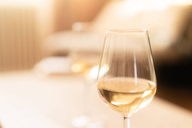 istock Two glasses of white wine on a rustic wooden table at home 2192138064