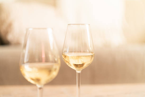 istock Two glasses of white wine on a rustic wooden table at home 2192138066