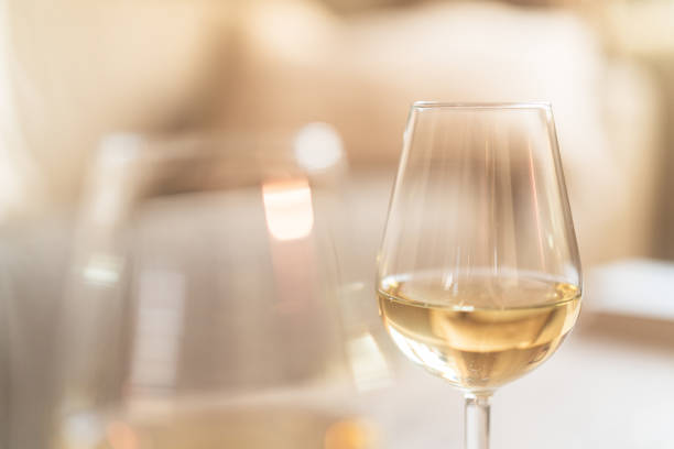 istock Two glasses of white wine on a rustic wooden table at home 2192138086