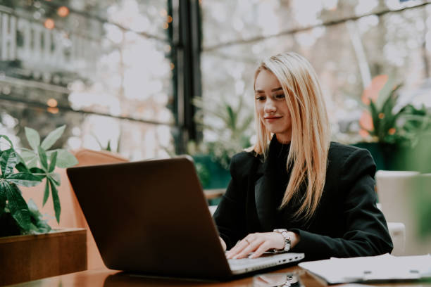 istock Female Entrepreneur Looking Joyful While Typing on Laptop From Nicely Decorated Office 2192139064