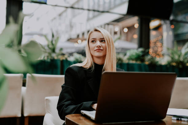 istock Beautiful Female Employee Getting Distracted While Typing on Laptop Looking Through Window 2192139071