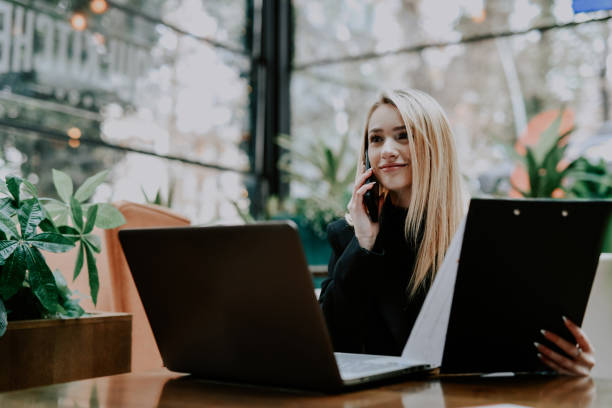 istock Smiling Female Entrepreneur Working Remotely Multitasking Talking on Phone and Checking Notes 2192139091