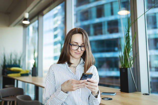 istock Mid adult woman using mobile at the office 2192140827
