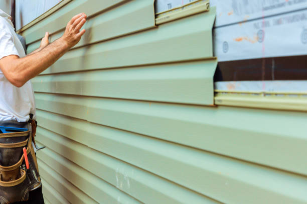 istock Worker installing green siding on a house while ensuring proper alignment and fit during home renovation 2192142383