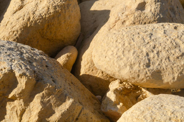 Detailed close-up of yellow limestone rocks with rugged textures, ideal for backgrounds, geology themes, and natural design projects