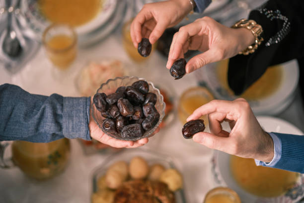 istock Happy Muslim family having iftar dinner to break fasting during Ramadan dining table at home or restaurant. 2192143768