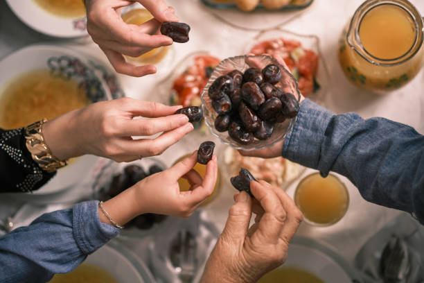 istock Happy Muslim family having iftar dinner to break fasting during Ramadan dining table at home or restaurant. 2192144889