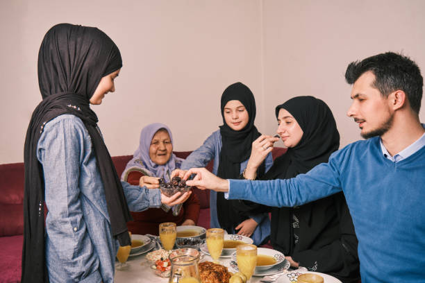 istock Happy Muslim family having iftar dinner during Ramadan dining table eating dates to break fast eid mubarak. 2192145402