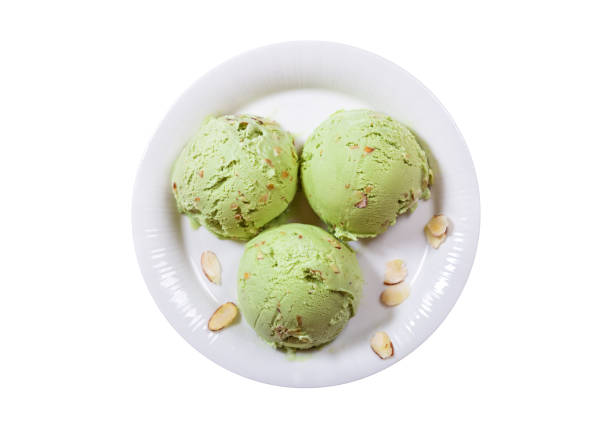 plate of pistachio ice cream scoops isolated on white background, top view