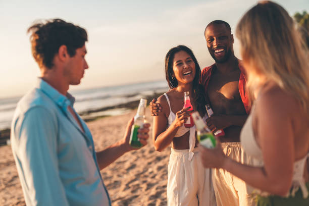 istock Group of friends enjoying drinks on the beach during sunset 2192148821