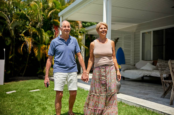 istock Happy senior couple holding hands and walking in backyard 2192153211