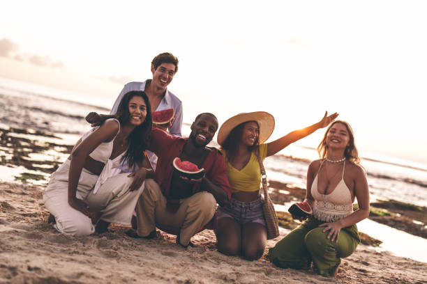 istock Group of friends enjoying a beach day together while sharing fresh watermelon 2192157423