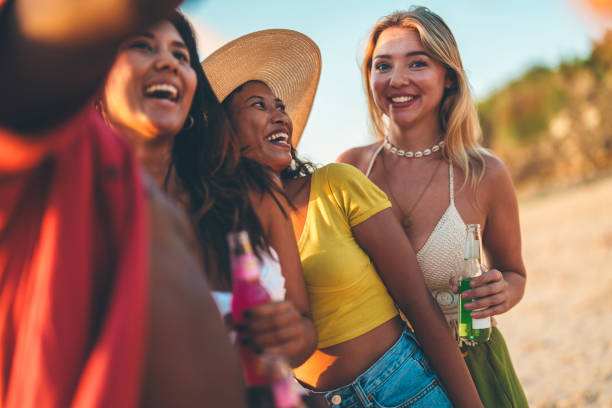 istock Happy group of women enjoying drinks outdoors on a sunny beach vacation 2192157426