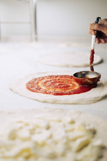 Authentic Italian Pizza Being Prepared with Fresh Mozzarella, Tomato Sauce, and Toppings, Captured During Handmade Crafting in an Italian Restaurant