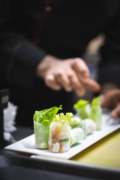 A high-resolution image showcasing a tray full of golden-brown spring rolls, neatly arranged in rows. Each piece is uniformly fried to a crisp, highlighting their appetizing texture and color. Perfect for catering services, buffet presentations, or food advertisements, this image captures the delicious appeal and professional food preparation ideal for commercial use.