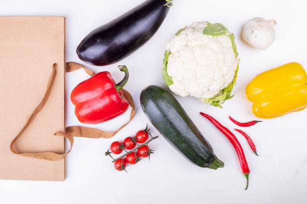 vegetables and an eco-friendly paper bag on a light background