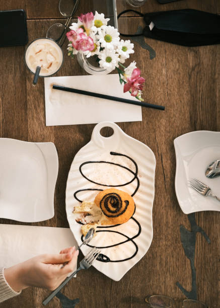 istock Delicious Cinnamon Roll Dessert Drizzled with Chocolate Sauce, Served on a Decorative White Plate in a Cozy Thai Restaurant 2192161571