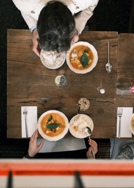 istock Overhead View of Red Curry Served with Jasmine Rice on a Rustic Wooden Table in a Thai Restaurant 2192161699