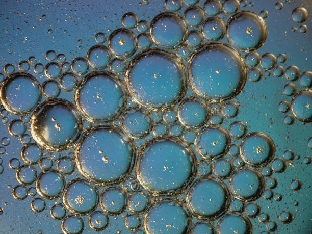 Close-Up View of Oil Bubbles on a Blue Liquid Surface.
