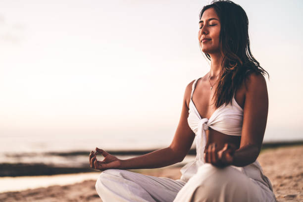 istock Woman meditating peacefully on the sandy beach during a serene sunset moment 2192162855